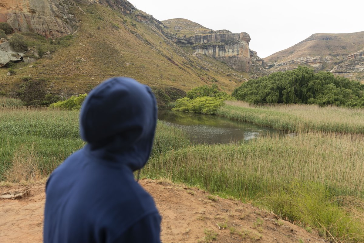 Black man sitting watching the mountains