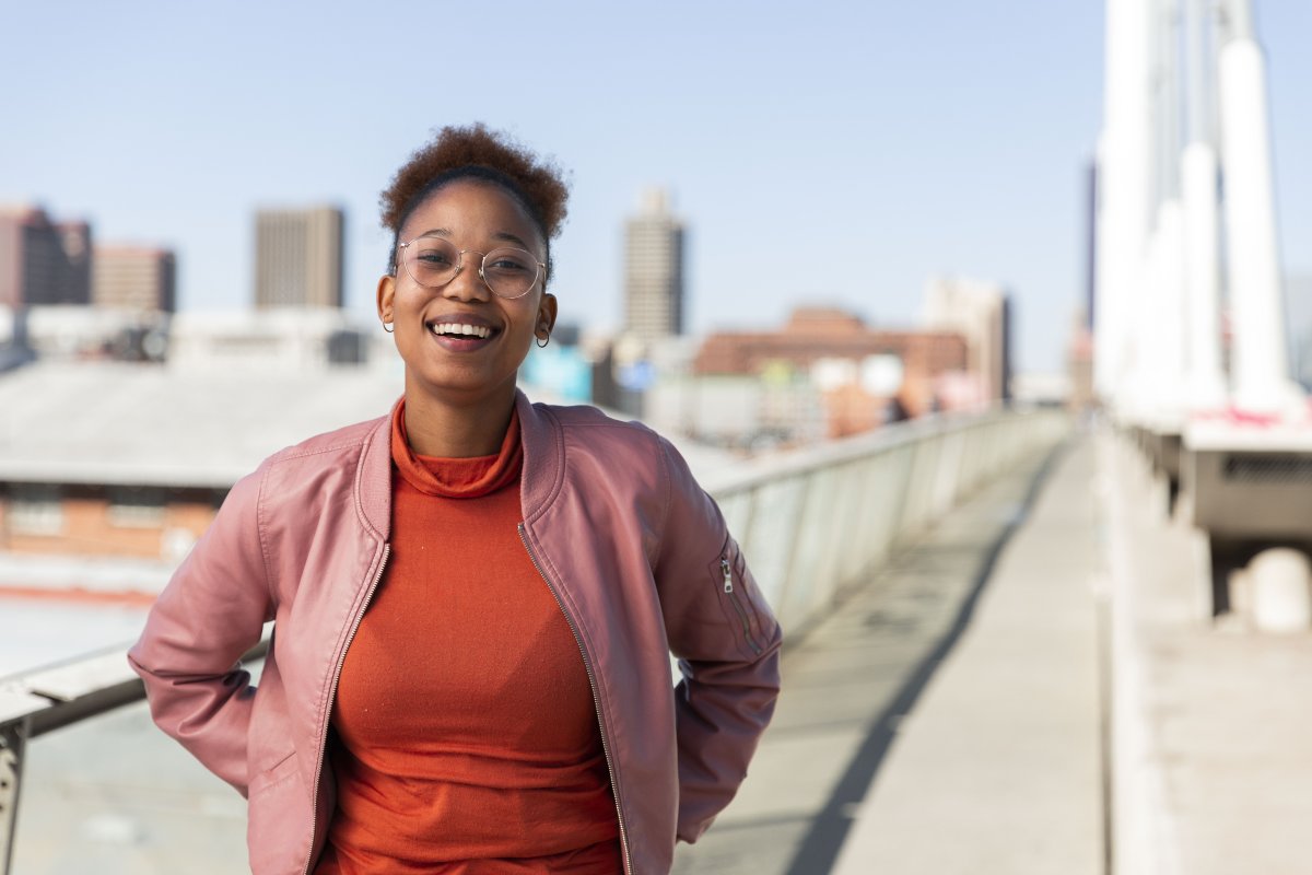Black woman on Nelson Mandela bridge grinning with glasses