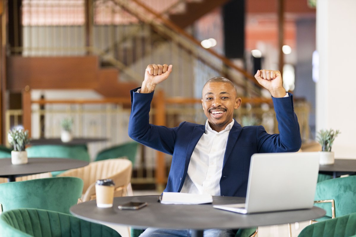 Black business man  celebrating with arms in the air