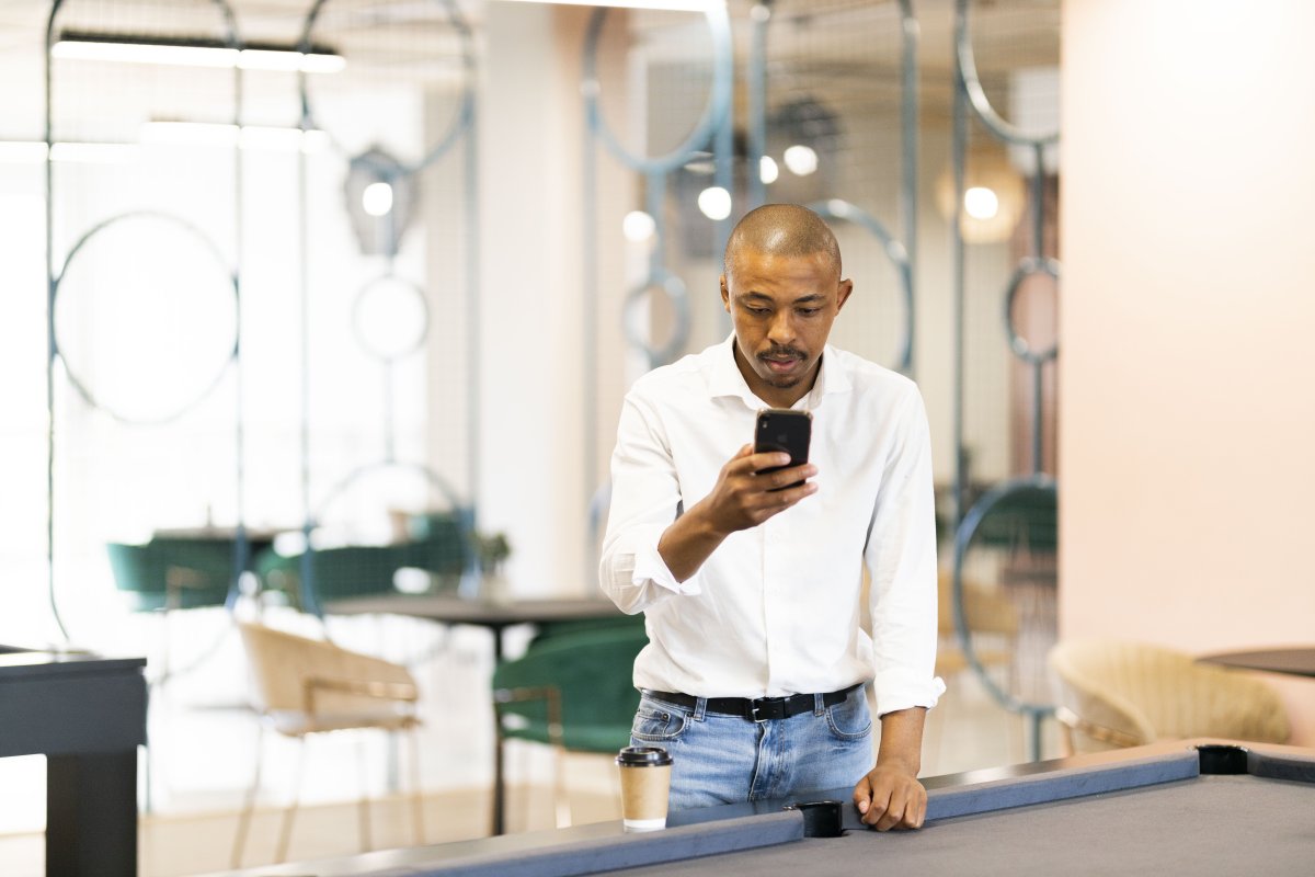 Black business man looking at smartphone