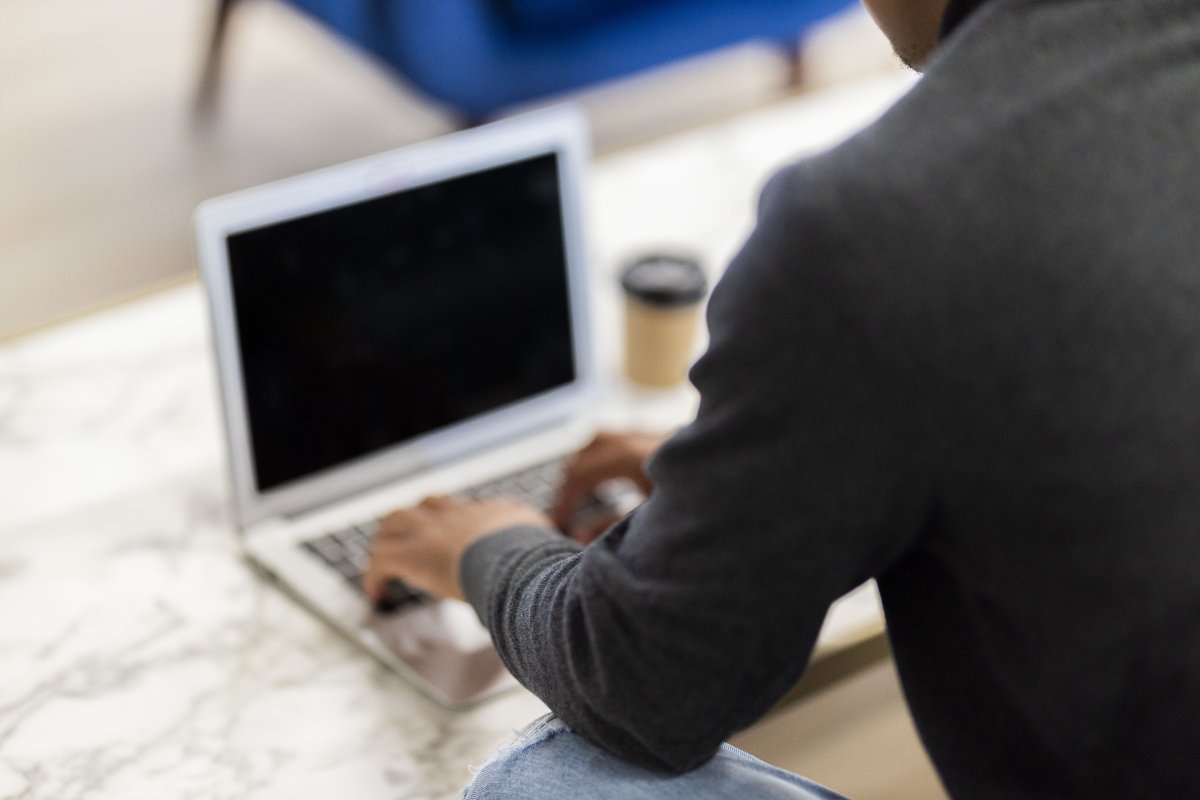Black man working on his laptop with coffee