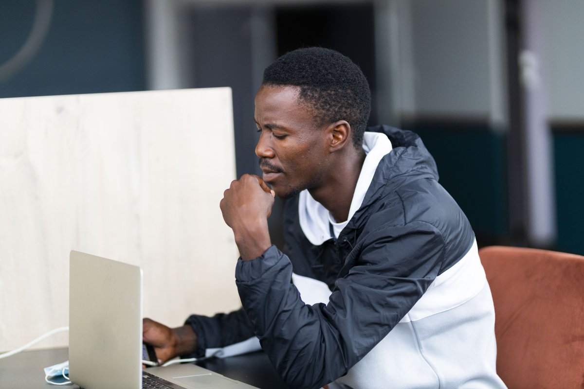 Black man looking at his laptop