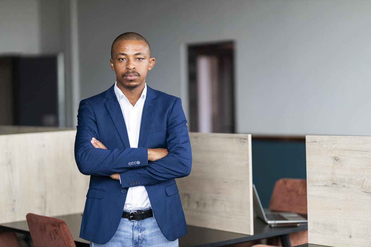 Black entrepreneur wearing a suit with folded arms