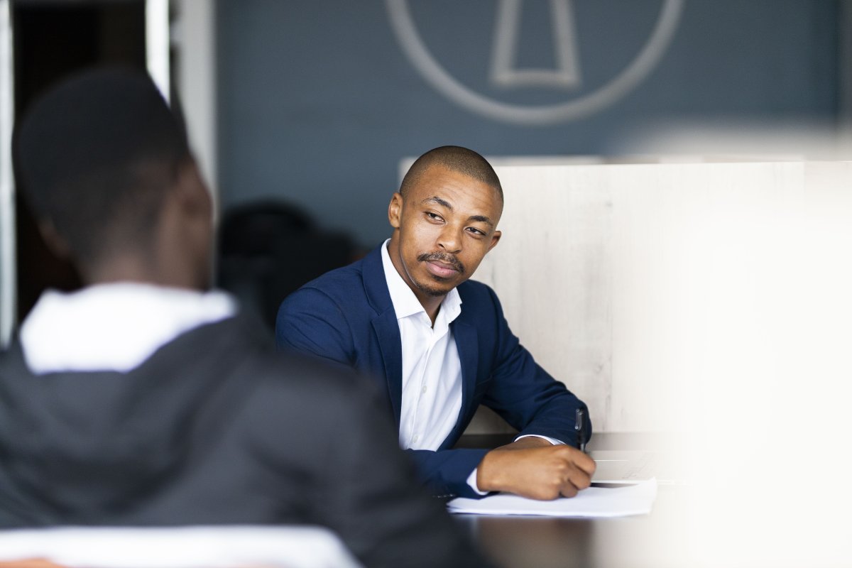 Black business man wearing a suit and talking to his client