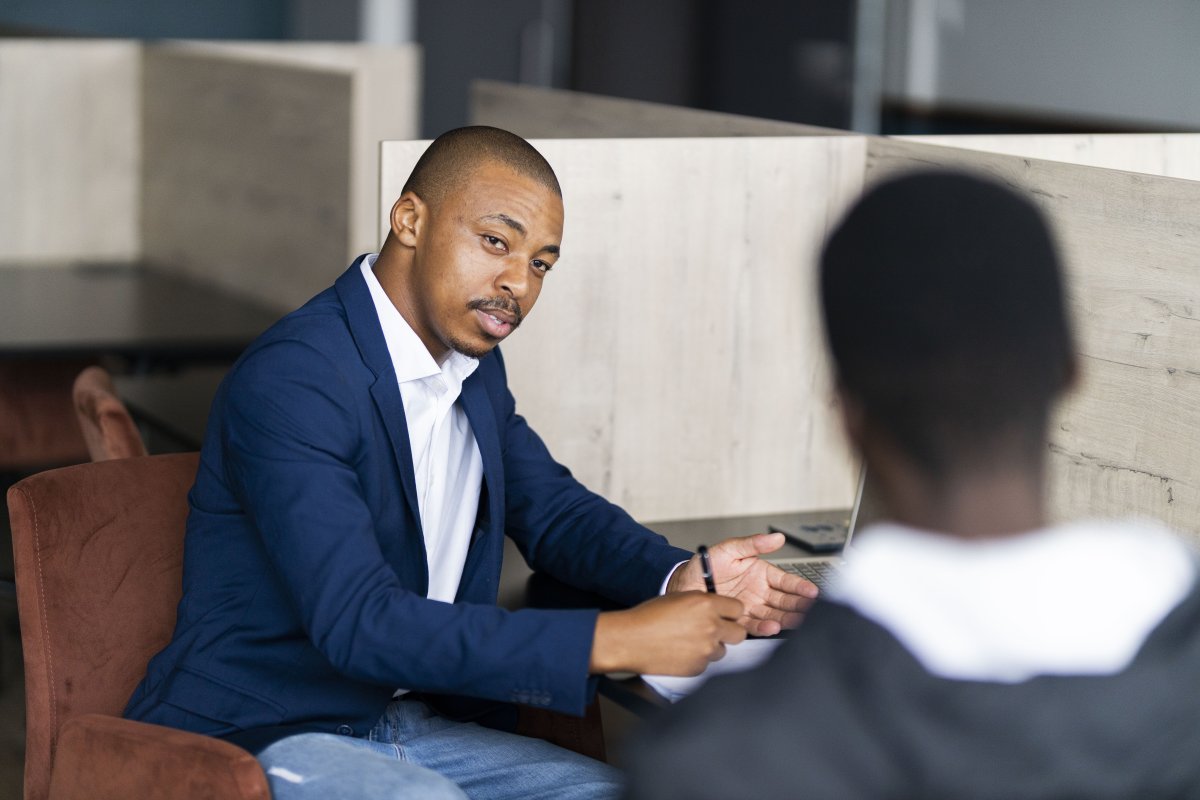 Black business man wearing a suit and talking to a client