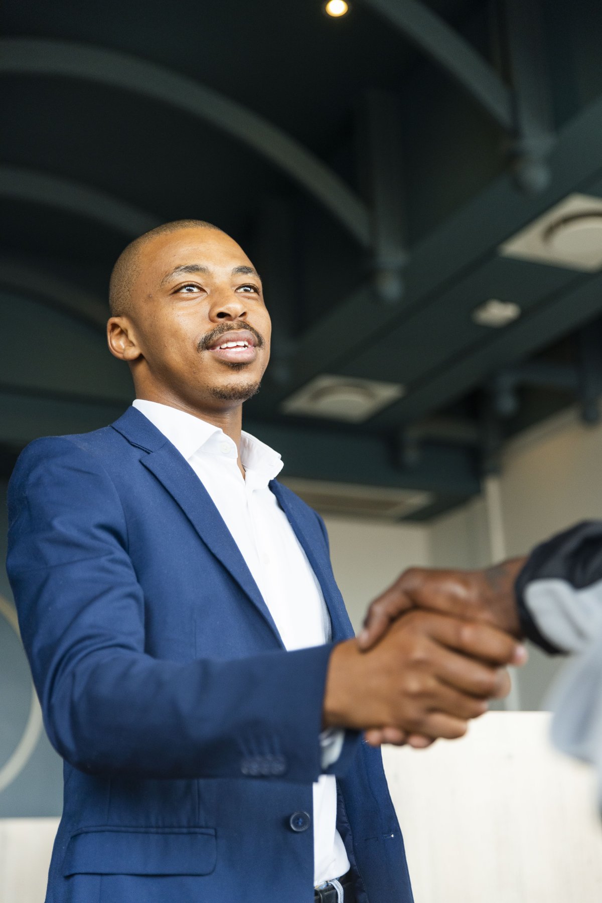 Black business man hand shaking hands with a client at work