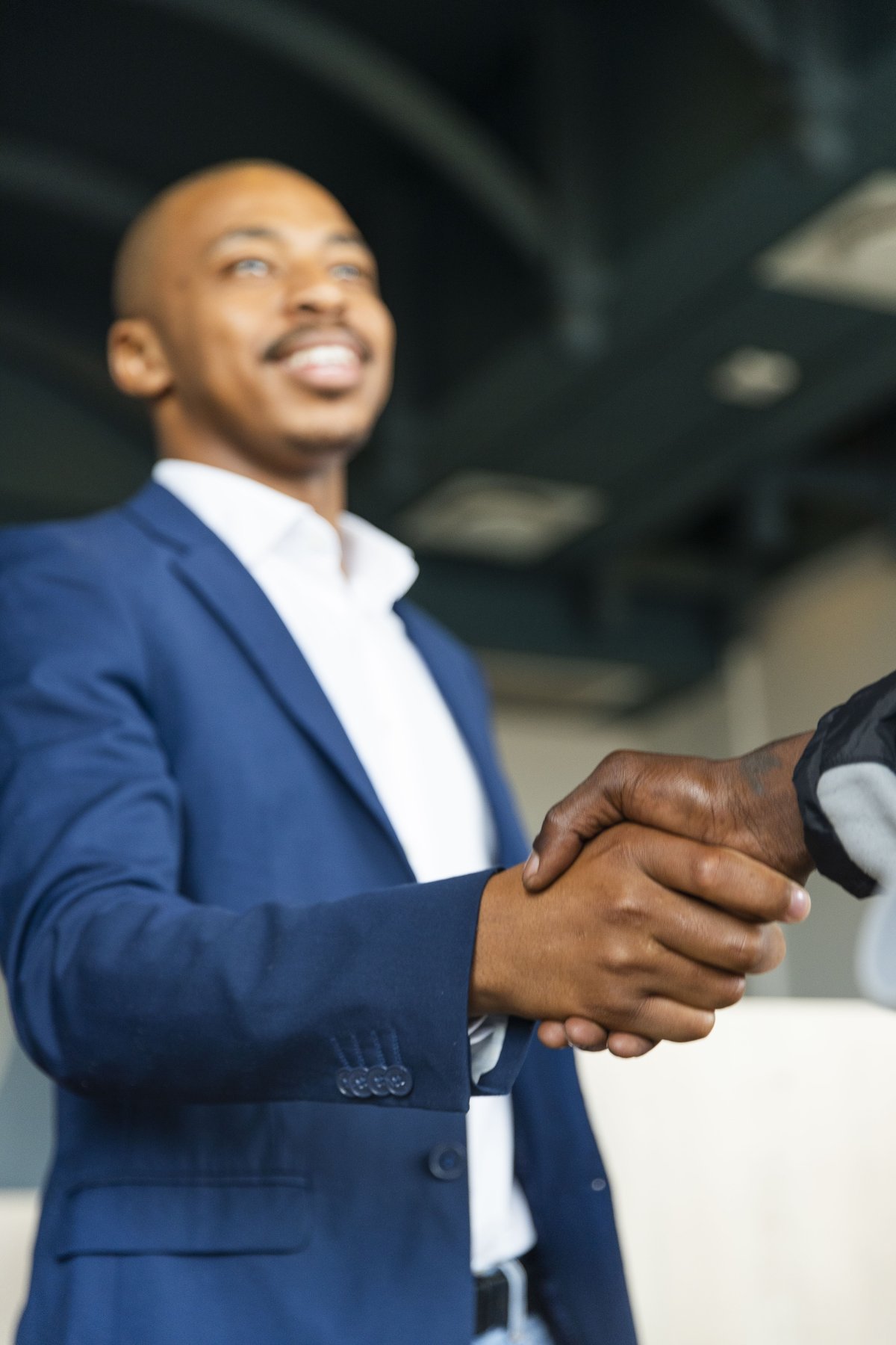 Black business man hand shaking a client at the office