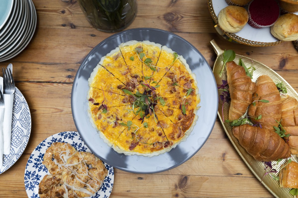 Plate of sliced pap with cheese, croissants on the side.