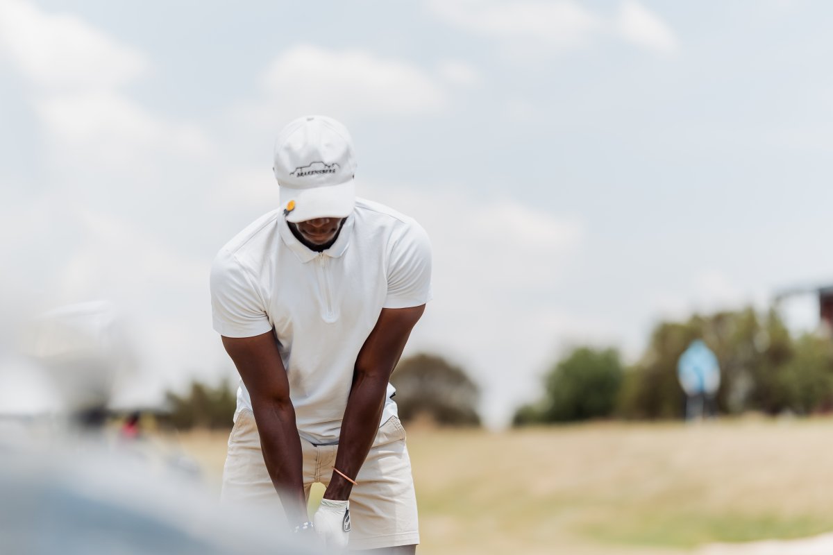 Black male golfer focusing on taking a golf shot