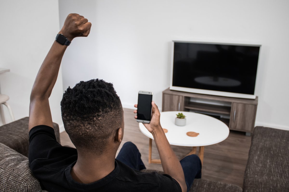 On the phone cheering from couch