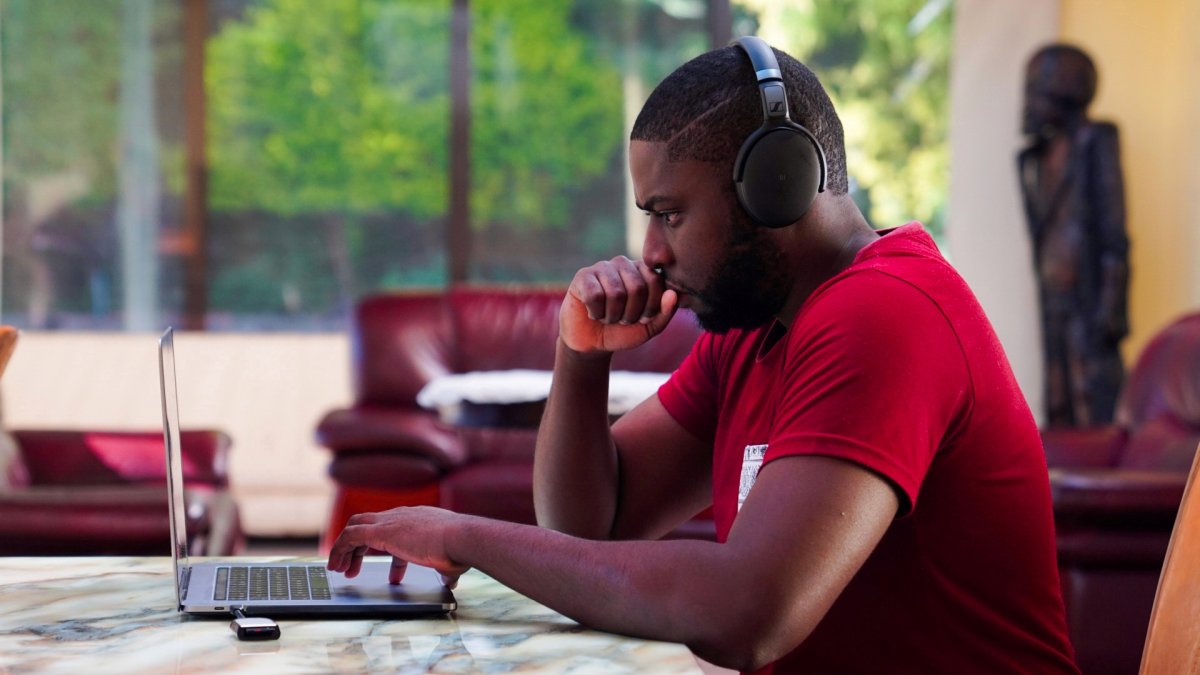 Black man working on laptop with headphones