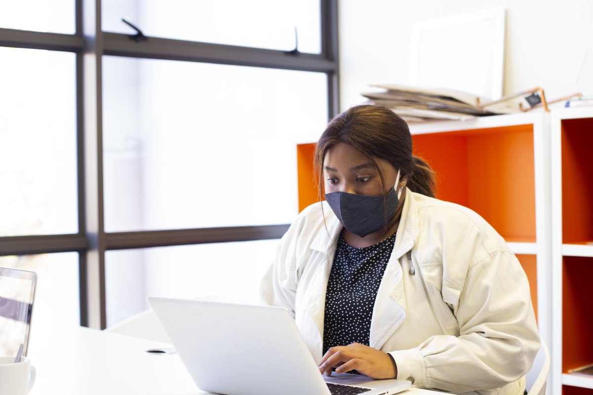 Business woman at the office wearing a mask