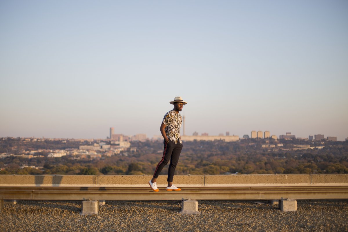 Black man posing in front of joburg skyline