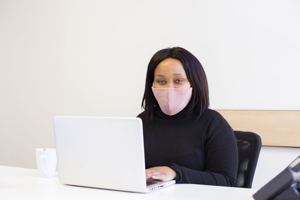 Black corporate woman wearing a mask at the office