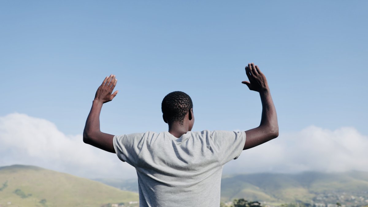Black man praying in the mountains