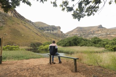 Black man sitting watching the mountains