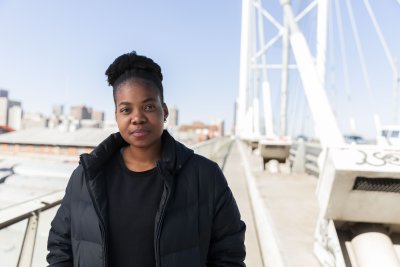 Black woman wearing all black on a bridge