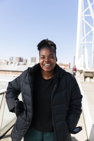 Black woman wearing all black laughing