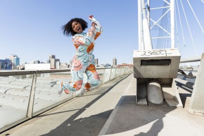 Black woman in the city jumping for joy
