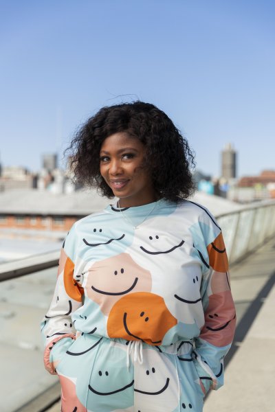 Black woman on Nelson Mandela bridge smiling with colourful clothing