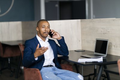 Black business man talking on his phone and wearing a suit