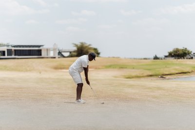 Black male golfer aiming at the green for a perfect shot