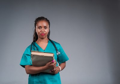 African doctor with a stethoscope, holding a book in her hands