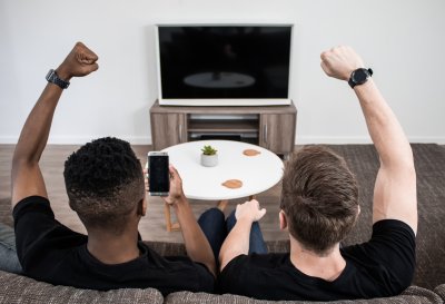 Two men cheering from the couch
