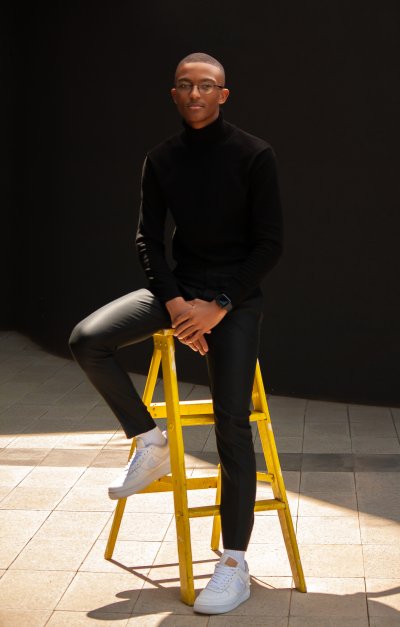 Black man sitting on a yellow ladder