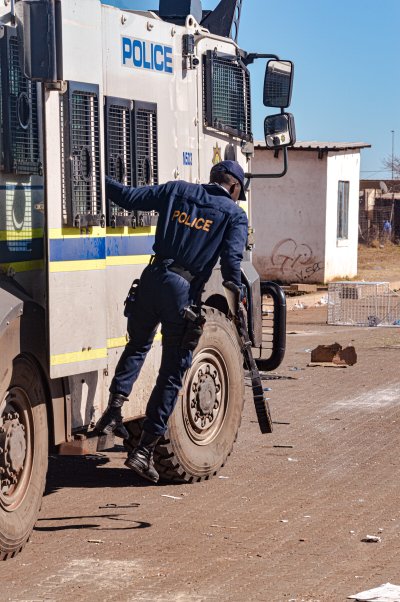 An SAPS member getting off the SAPS truck during an unrest South Africa faced.