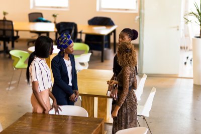 Black business women in an open area meeting