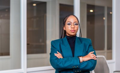 Young professional black woman wearing glasses with folded arms at the office.