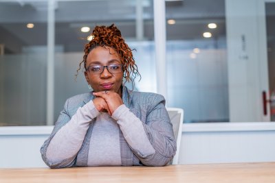 Mature black business woman looking at camera at work wearing glasses in a suit.