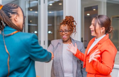 Excited mature black woman shaking hands with a new employee after employment contract.