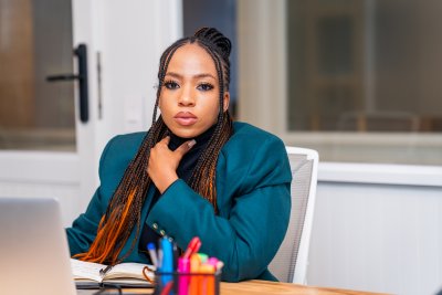 Young African business woman at the office wearing a green jacket.