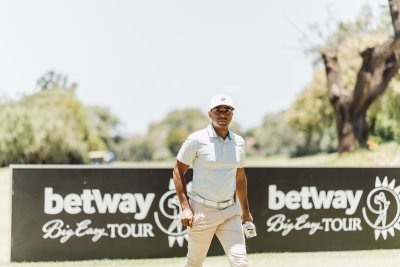 Golf player walking pass betray sign with glove in hand on a sunny day