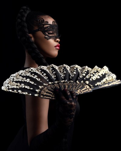 black woman posing in a masquerade mask